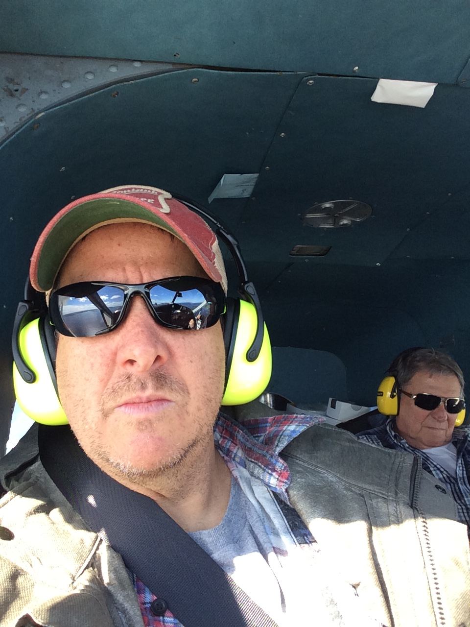 Jay in the cabin of a De Havilland Beaver, wearing ear protection